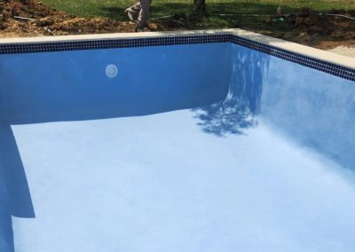 Finished concrete pool with blue interior.