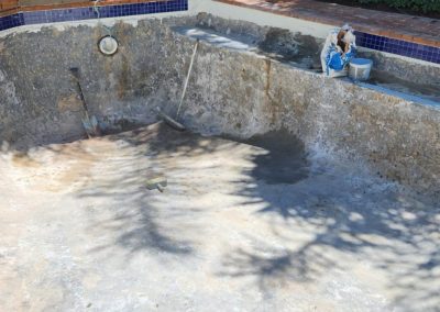 Scrubbing an old pool that needs renovations.